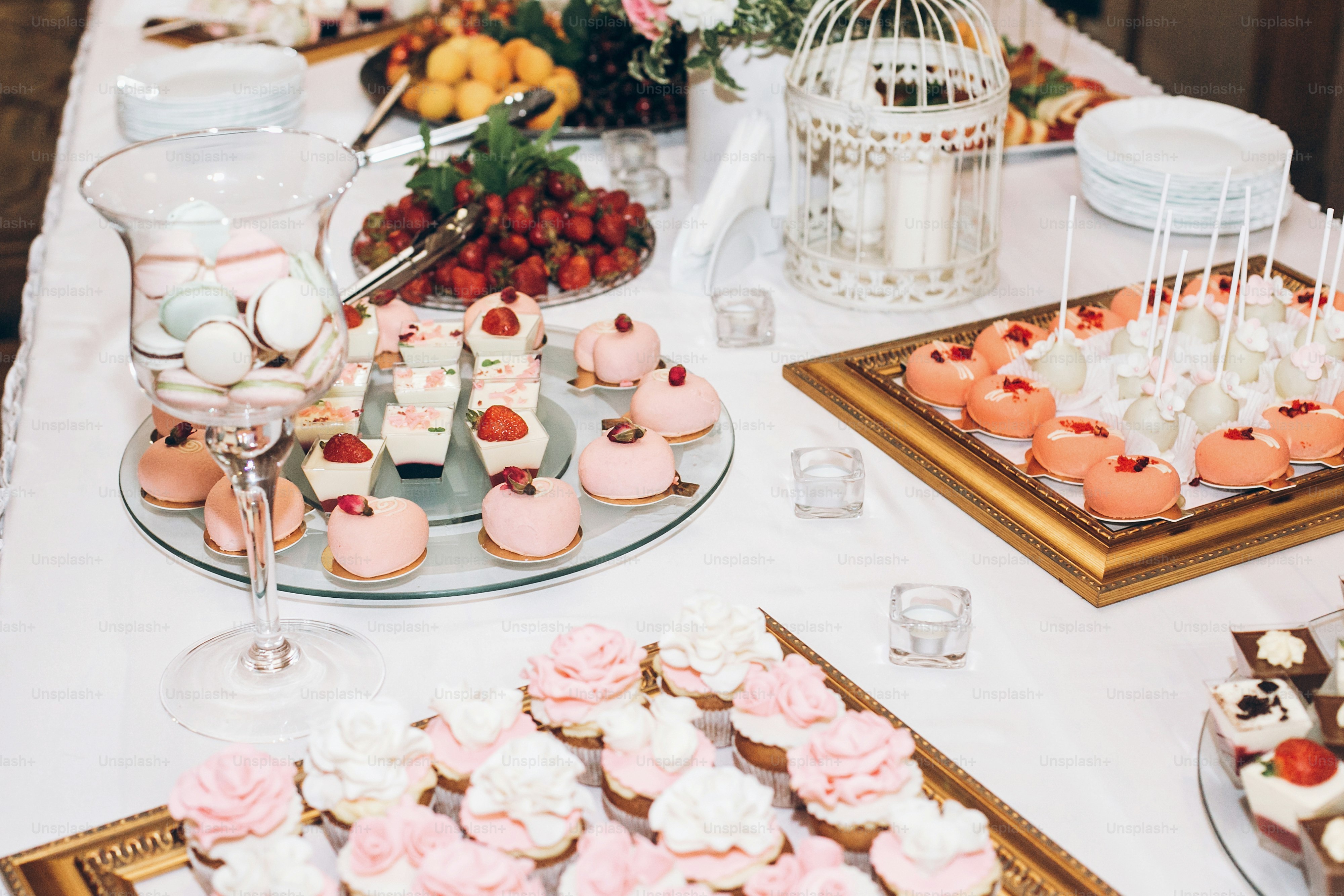 doces deliciosos, doces, cupcakes, pops decorados com flores na mesa na recepção do casamento. Chocolate. saborosos doces cor-de-rosa para celebrações de eventos e chuveiros. catering elegante de luxo