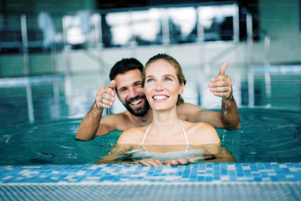Happy attractive couple relaxing in spa swimming pool