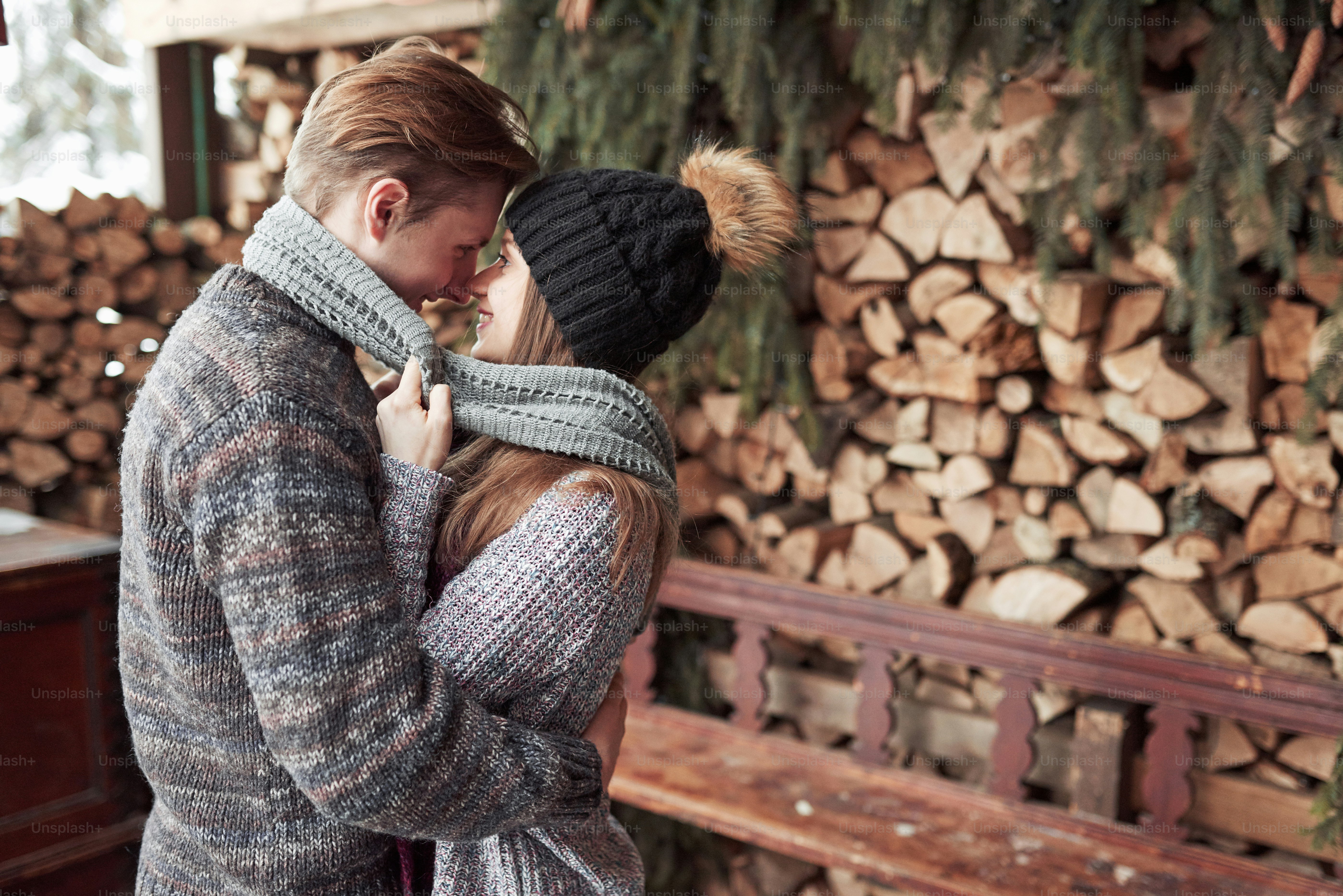 Couple has fun and laughs. kiss. Young hipster couple hugging each other in winter park. Winter love story, a beautiful stylish young couple. Winter fashion concept with boyfriend and girlfriend.