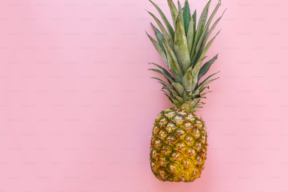 juicy pineapple on trendy pink paper background. modern minimalism flat lay. summer vacation and party concept. space for text.