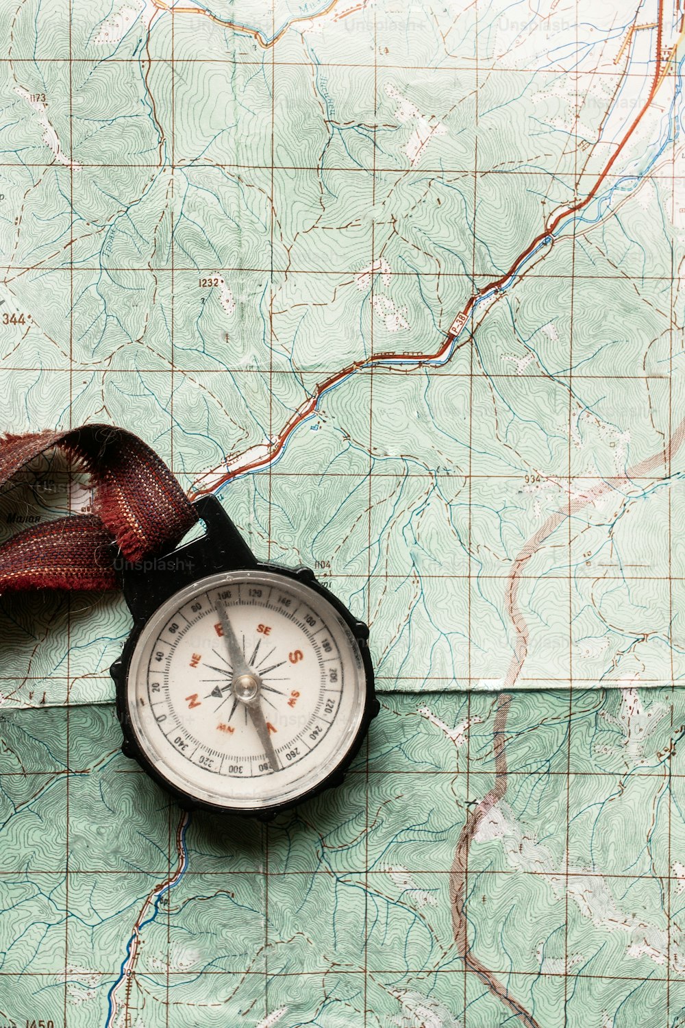 wanderlust and explore concept, old compass lying on map, top view, space for text, vintage toned image