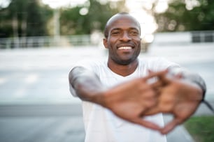 Portrait of cheerful male athlete doing workout. He gesticulating hands