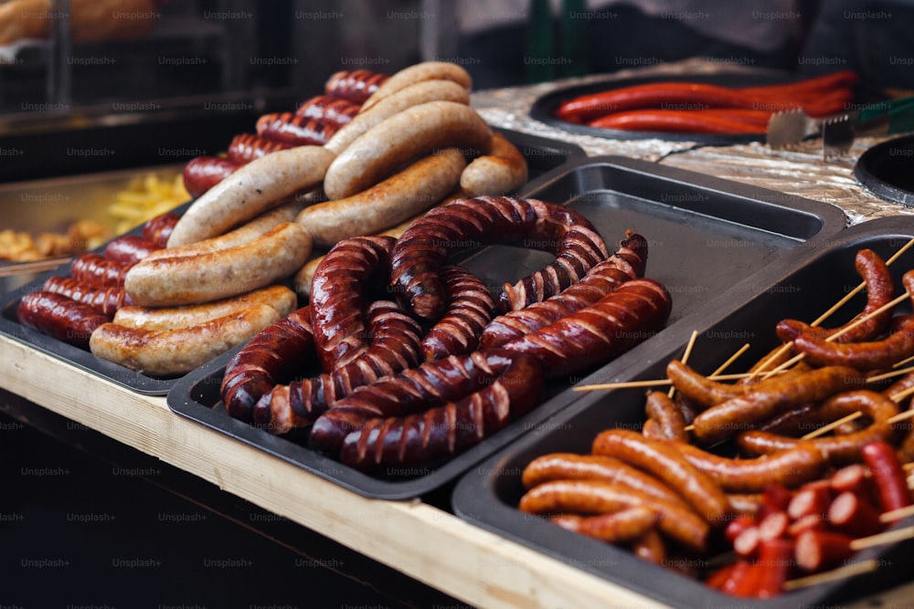 delicious sausages bbq at market fest, grilling on open grill, outdoor kitchen. food festival in city. tasty food roasting, food-court. summer picnic