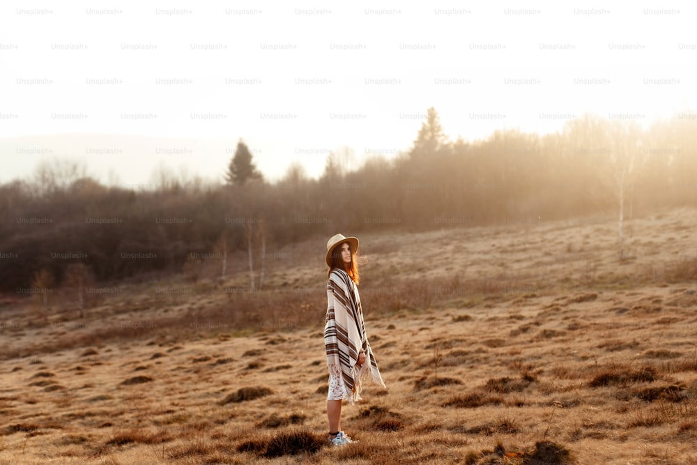 beautiful boho woman hipster enjoying sunset and posing at sun light  in mountains, space for text, amazing moment