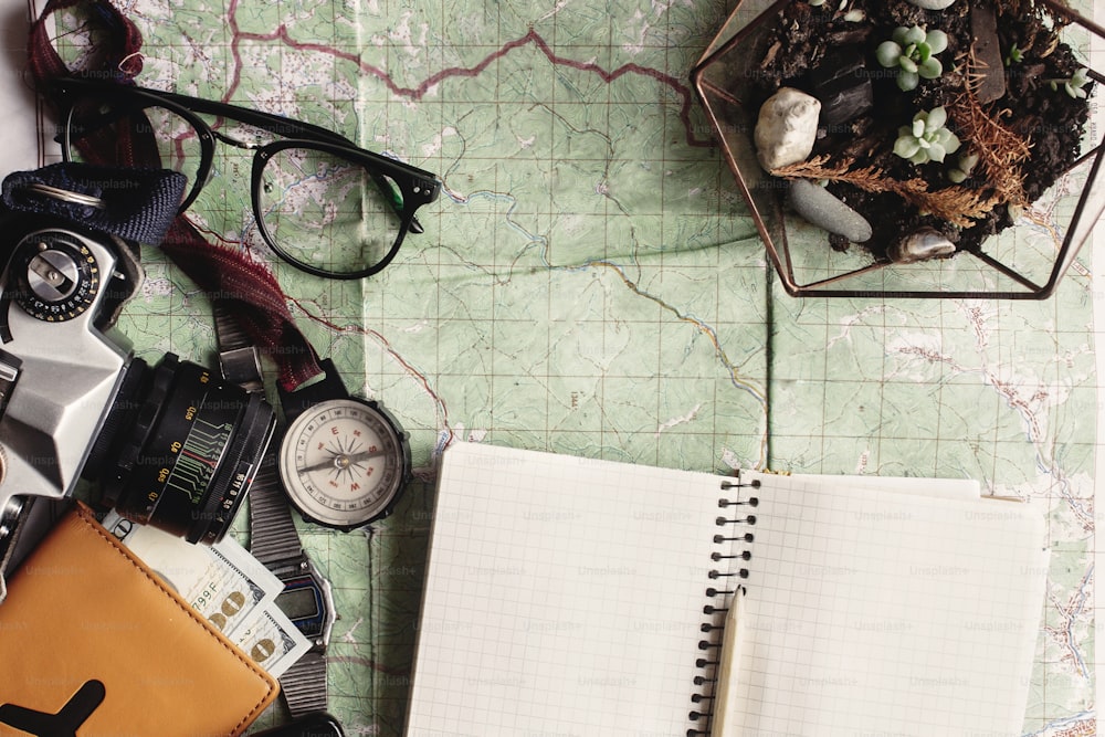 wanderlust and adventure concept, compass camera glasses passport money notebook lying on map, top view, space for text, vintage toned image