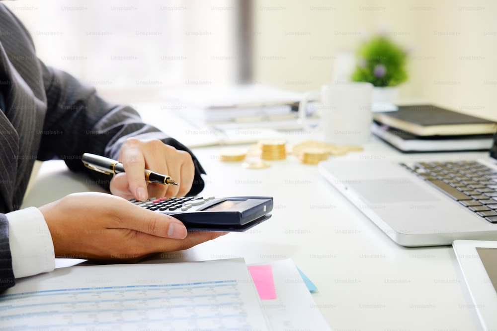 Primo piano business calcolare la carta del documento di dati finanziari con calcolatrice.