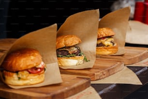 delicious burgers on craft paper, serving bbq at open grill, outdoor kitchen. food festival in city. tasty food roasting, food-court. summer picnic