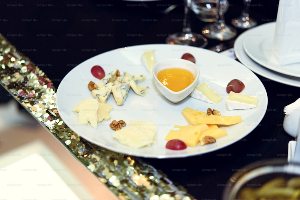 スタイリッシュで豪華な装飾が施されたテーブルには、誕生日のお祝いのためのチーズの前菜、レストランでのキャテリング