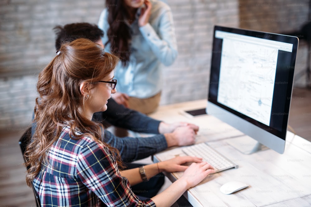 Young architects working on project in office together