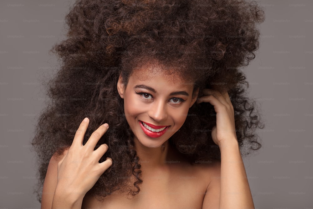 Beauty-Porträt einer attraktiven afroamerikanischen Frau mit langer Afro-Frisur und Glamour-Make-up, Studioaufnahme.