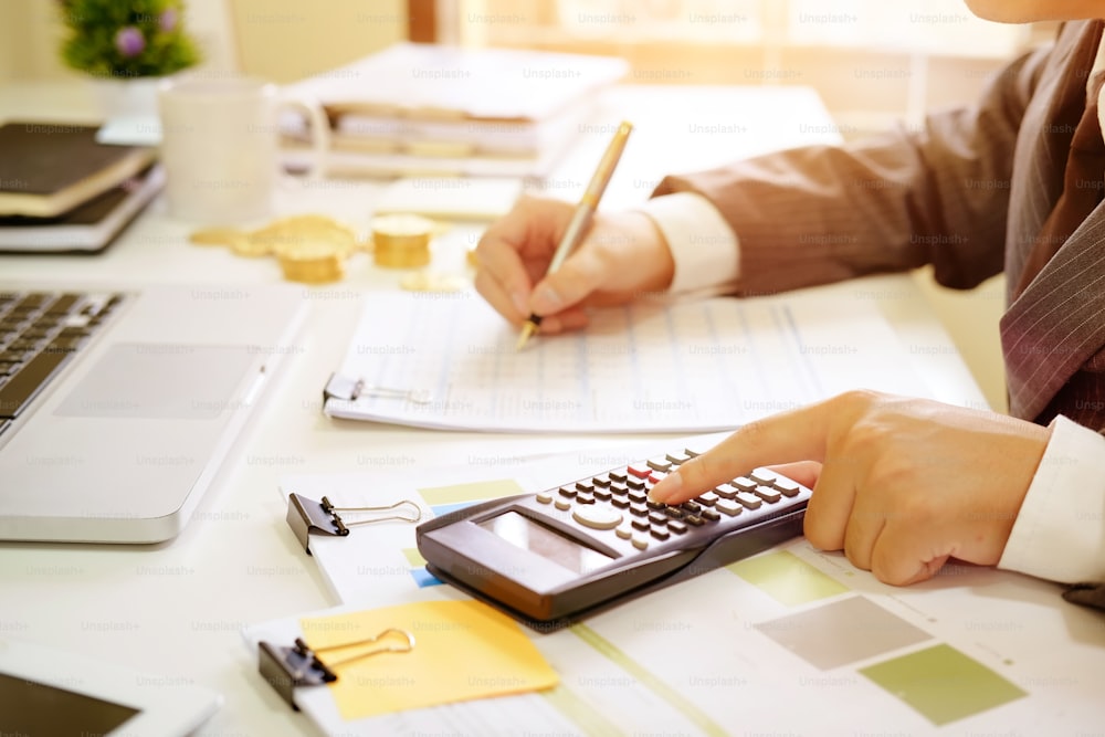 Gros plan d’entreprise calculer le document de données financières papier avec calculatrice.