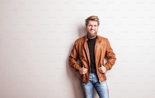 Portrait of a young handsome hipster man in a studio. Copy space.