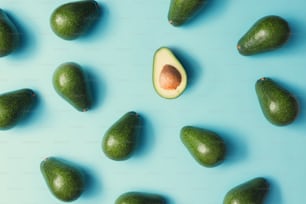 Avocado colorful pattern on a pastel blue background. Summer concept. Flat lay.