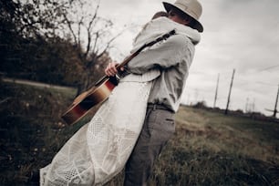 세련된 힙스터 커플이 들판에서 포옹하고, 기타를 든 잘생긴 카우��보이 뮤지션, 흰색 스웨터를 입은 인디 스타일의 여성이 기차역 근처에서 포즈를 취하고 있다