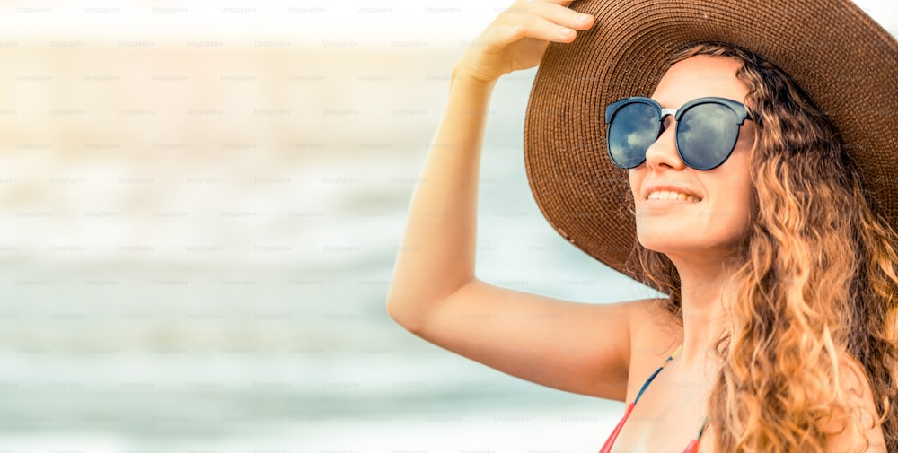 Happy young woman wearing swimsuit having good time at tropical beach in summer for holiday travel vacation.