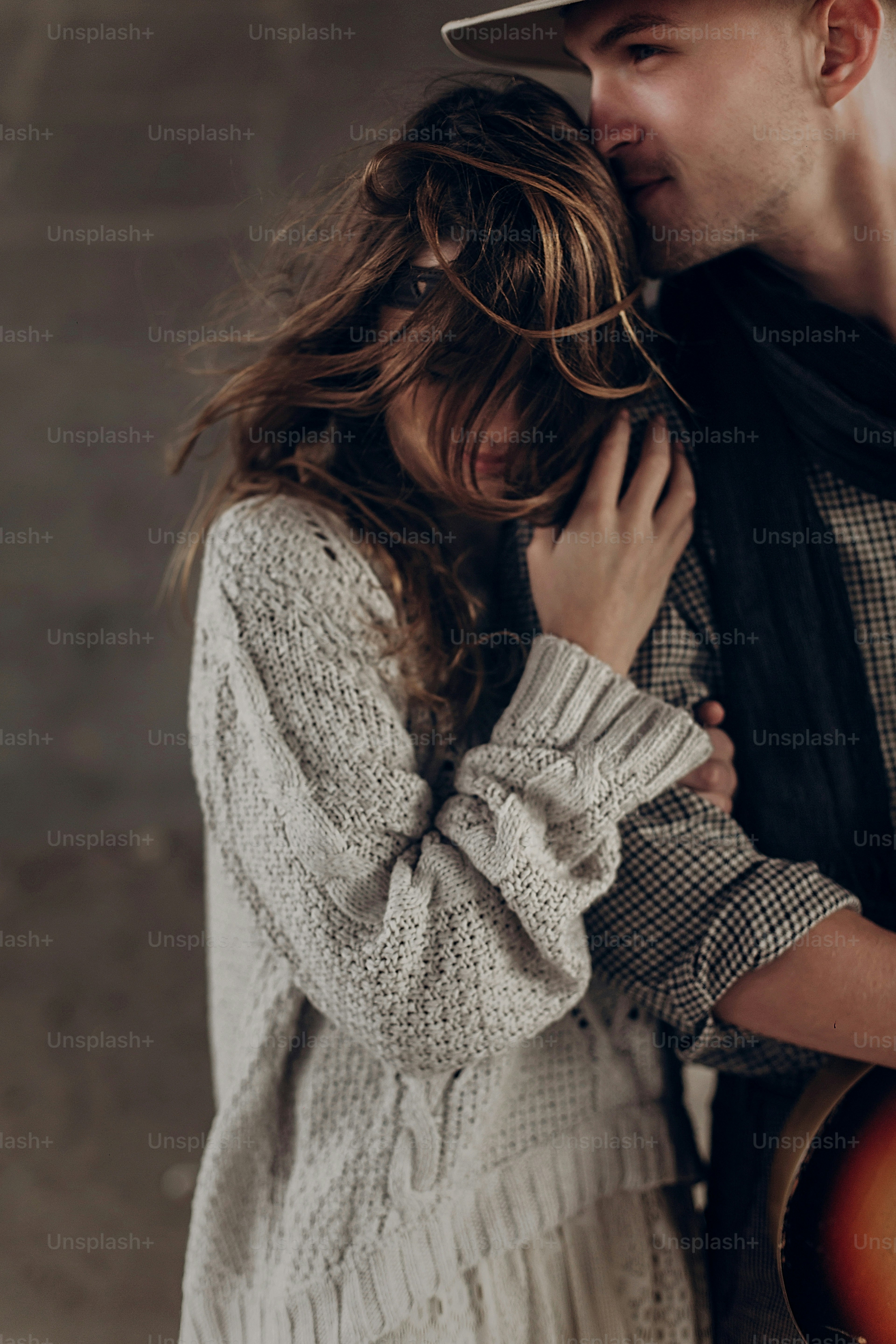 Handsome cowboy man with a guitar kissing beautiful indie woman , while posing outdoor