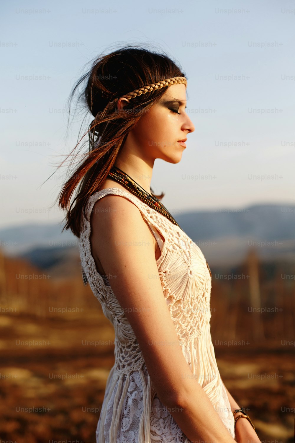 beautiful boho woman relaxing in sunny evening on top of a mountain, peaceful inspirational moment