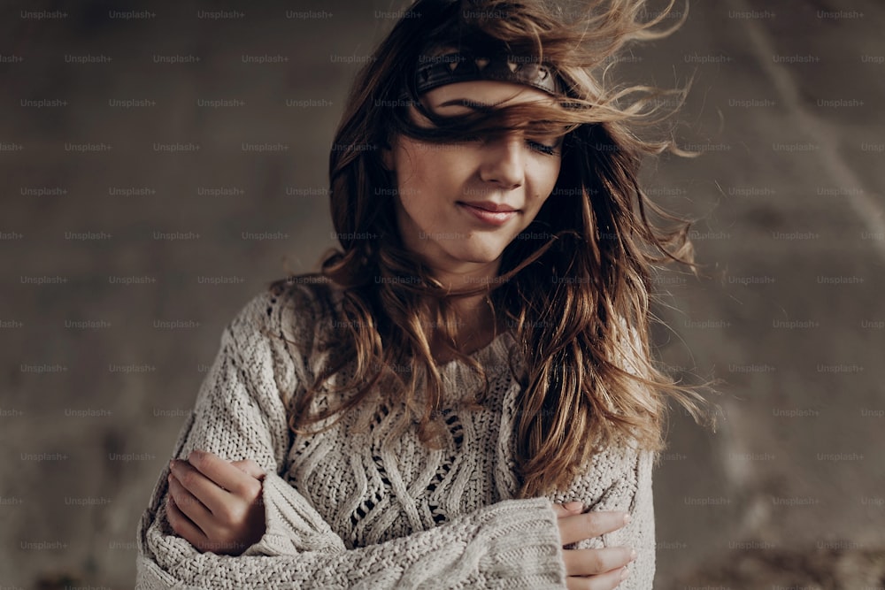 Beautiful hipster woman in boho indie clothes, posing in winter outdoor, face closeup, leather headband on brunnete hair