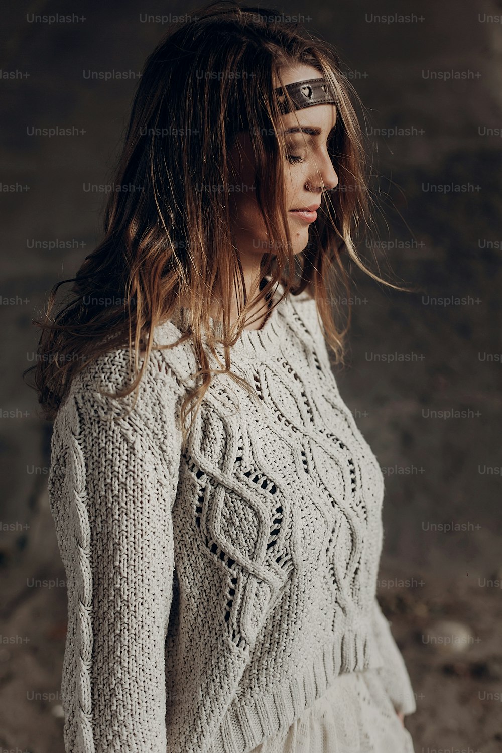 Stylish brunette hipster girl posing outdoors in knitted sweater