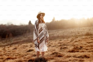 beautiful boho woman hipster enjoying sunset and posing at sun light  in mountains, space for text, amazing moment