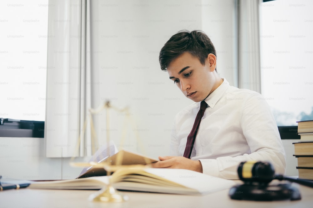 Young lawyer business man working with paperwork on his desk in office.