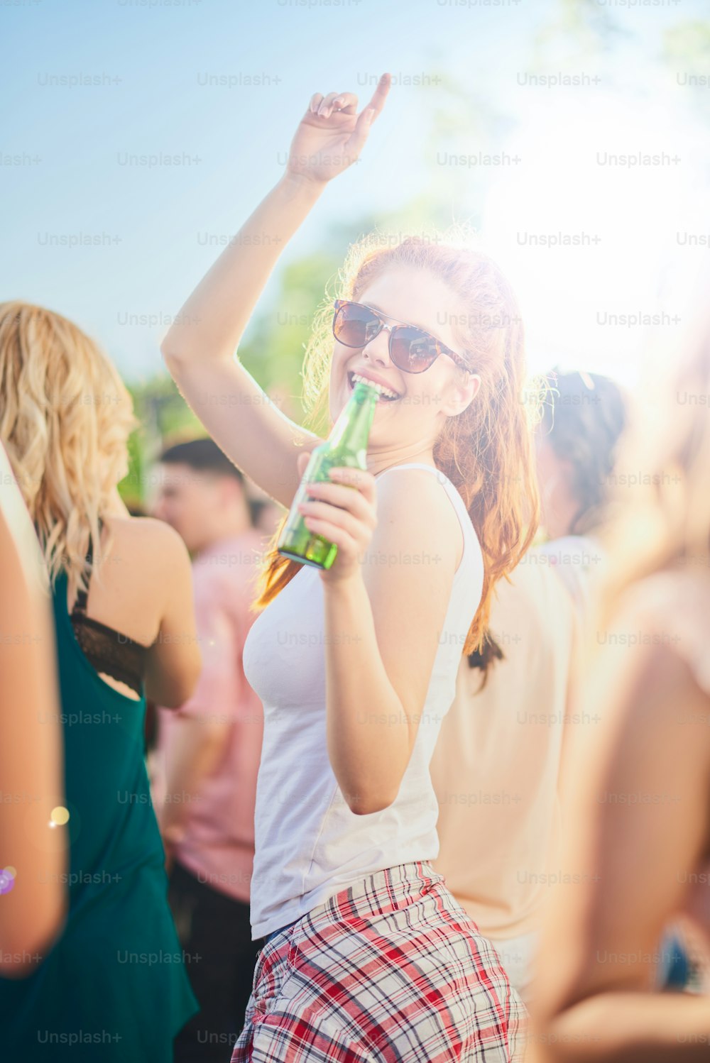 Ginger girl dancing, drinking an having a good time at outdoor party