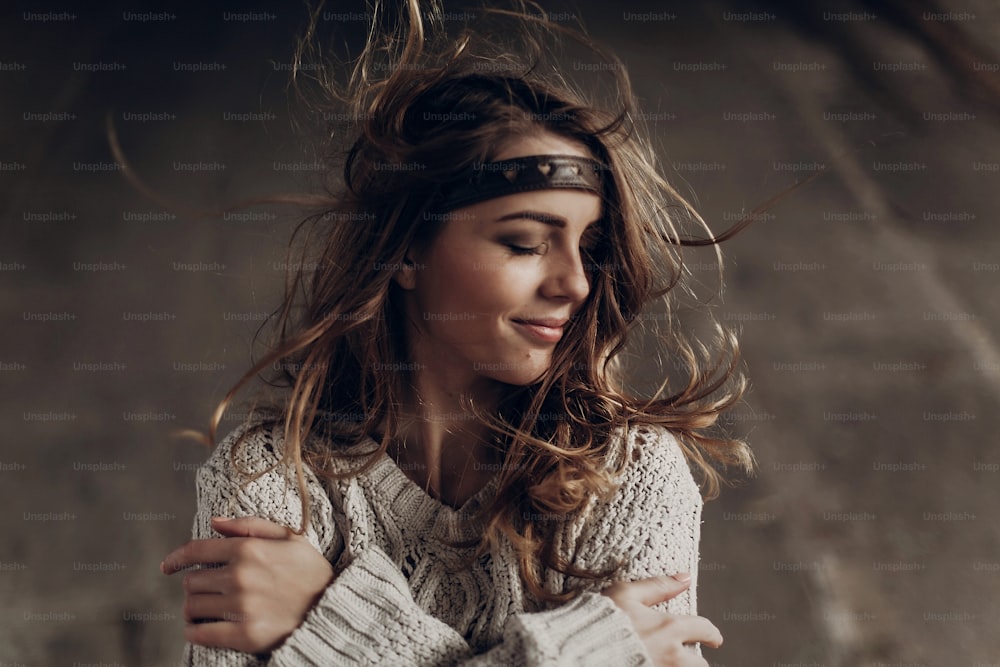 Beautiful hipster woman in boho indie clothes, posing in winter outdoor, face closeup, wind playing with hair
