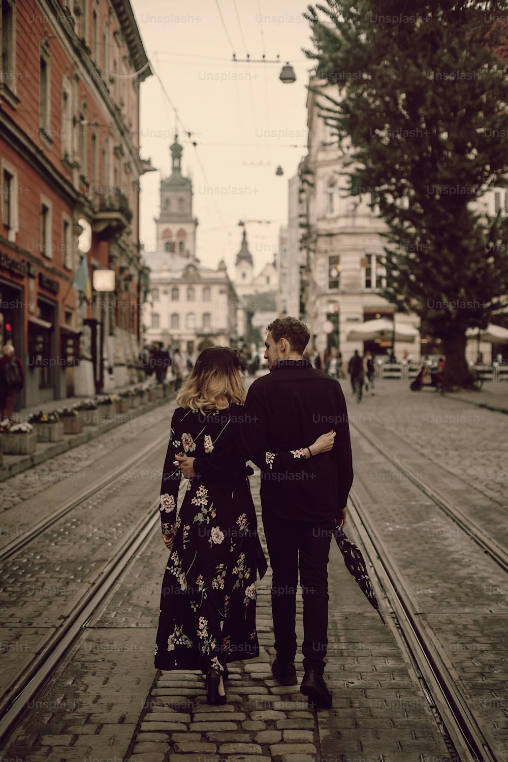 Stilvolles Zigeunerpaar verliebt spazieren und umarmen sich in der abendlichen City Street. Frau und Mann umarmen sich sanft, romantischer französischer atmosphärischer Moment. Liebesstimmung. Rückansicht