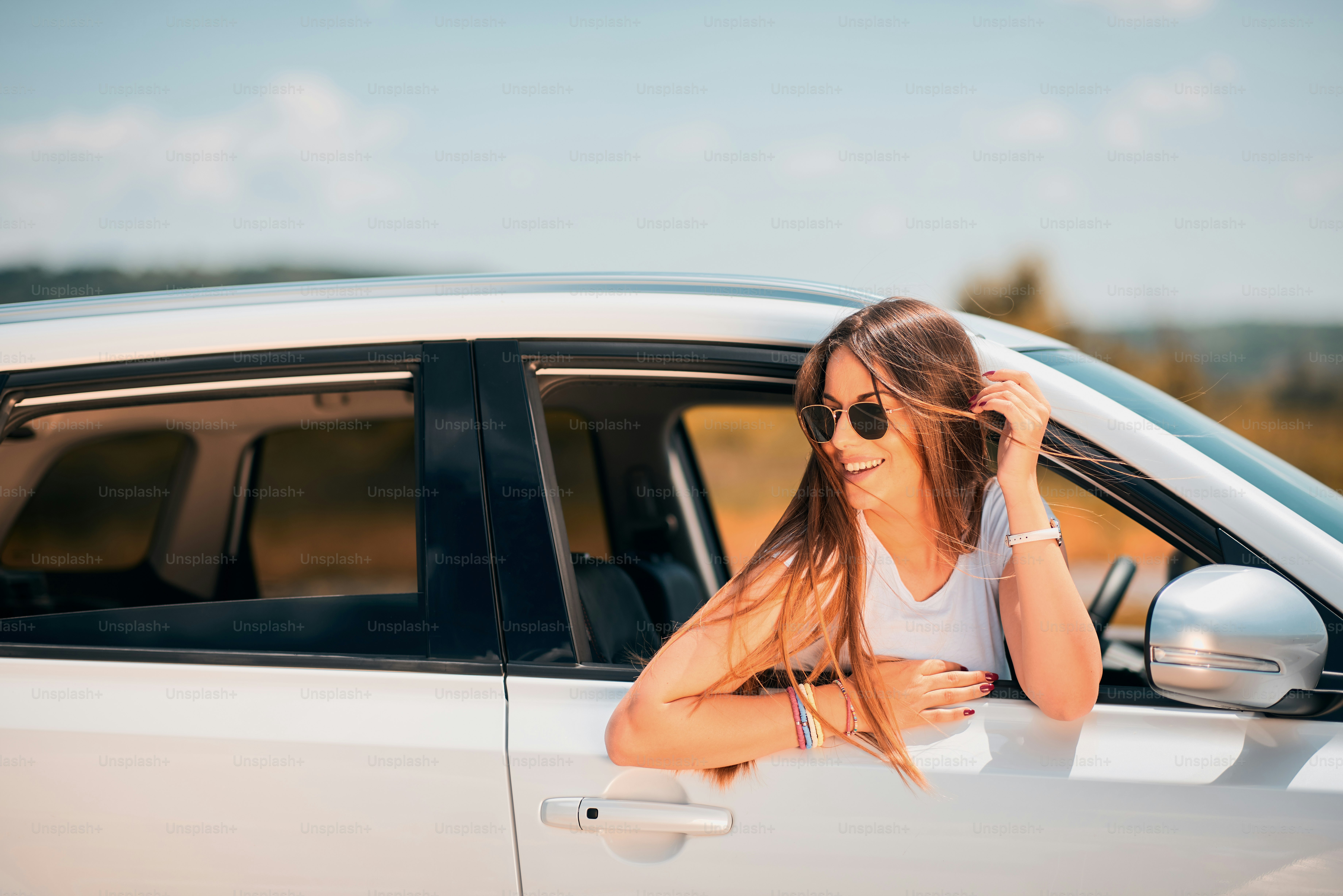 Woman posing while leaning on the car window.