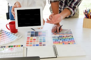 Graphic designer present something in digital tablet on artist workplace.