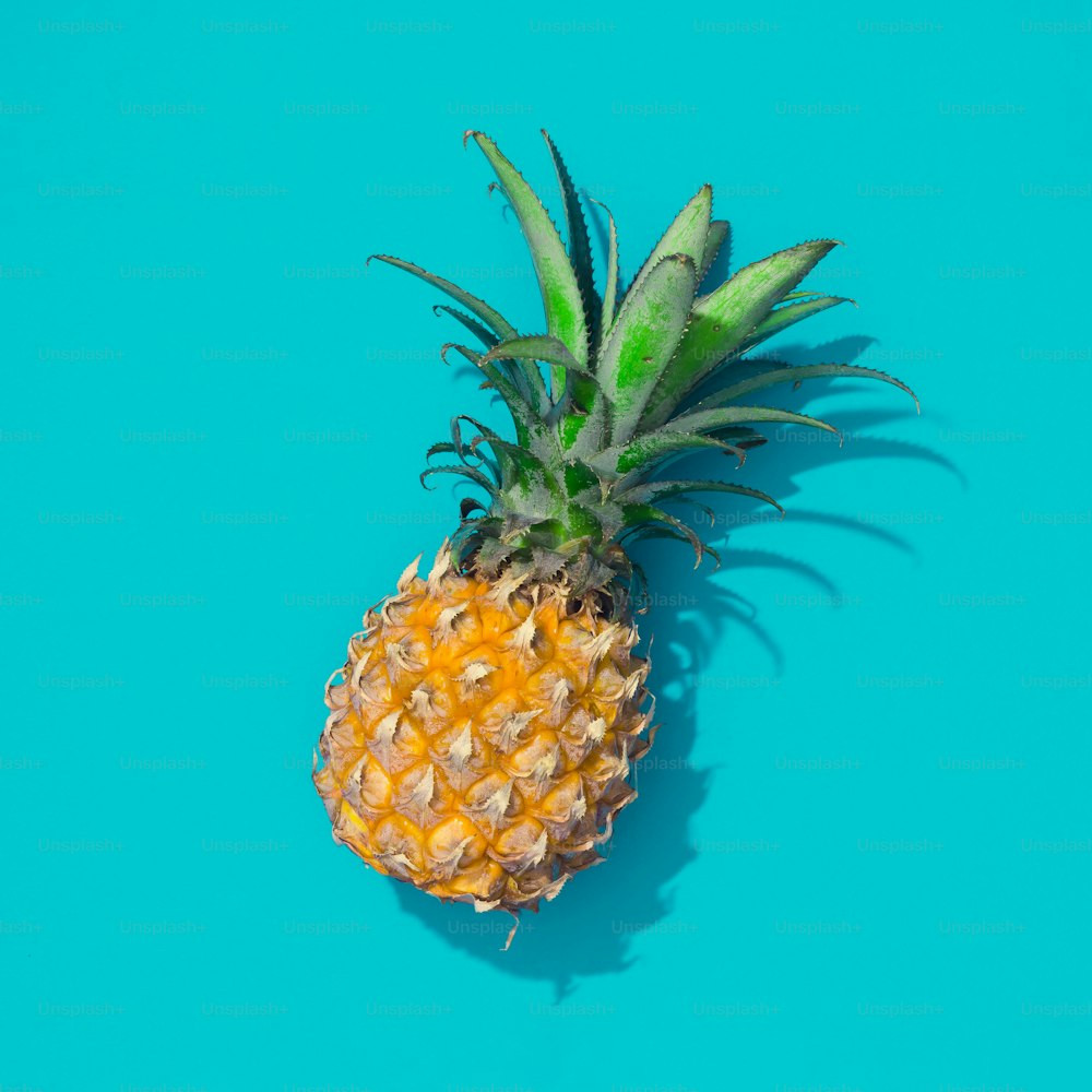Creative tropical layout with pineapple and blue vivid paper. Abstract food art background. Minimal summer concept. Flat lay.
