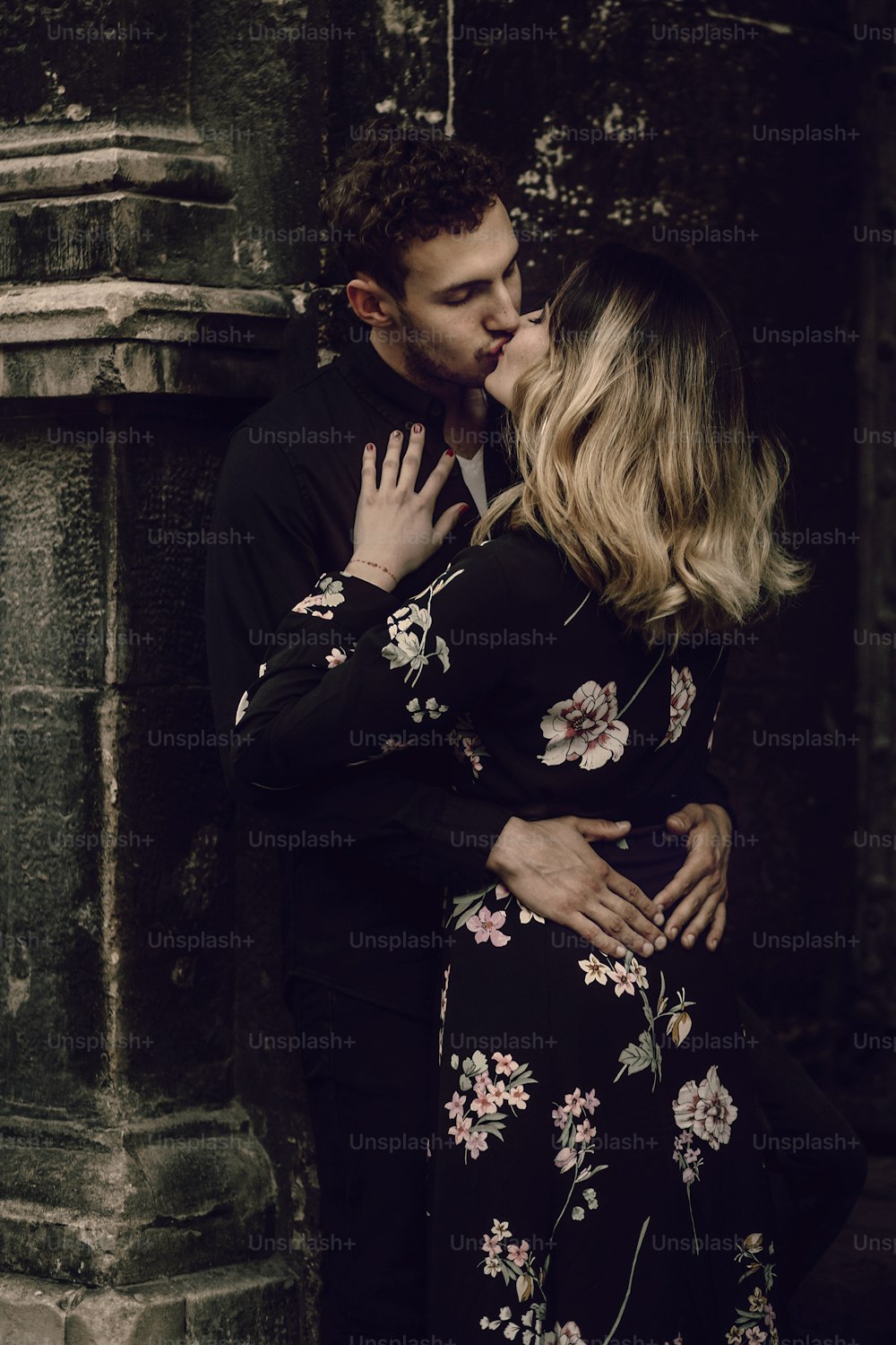 Stilvolles Zigeunerpaar verliebt küsst sich in der abendlichen City Street am Altbau. Frau und Mann umarmen, romantischer französischer atmosphärischer Moment. Liebesstimmung. Ungewöhnliche Braut und Bräutigam