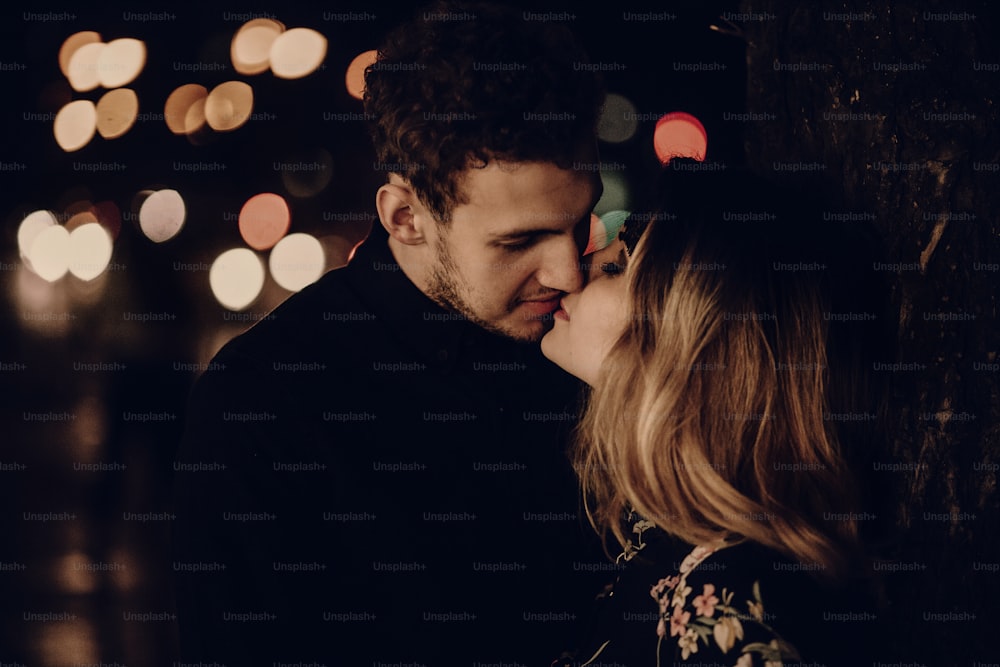 Amantes besándose por la noche, sensual retrato de la pareja cara de cerca, marido y mujer en luna de miel en París al aire libre luces de la ciudad, concepto de pasión