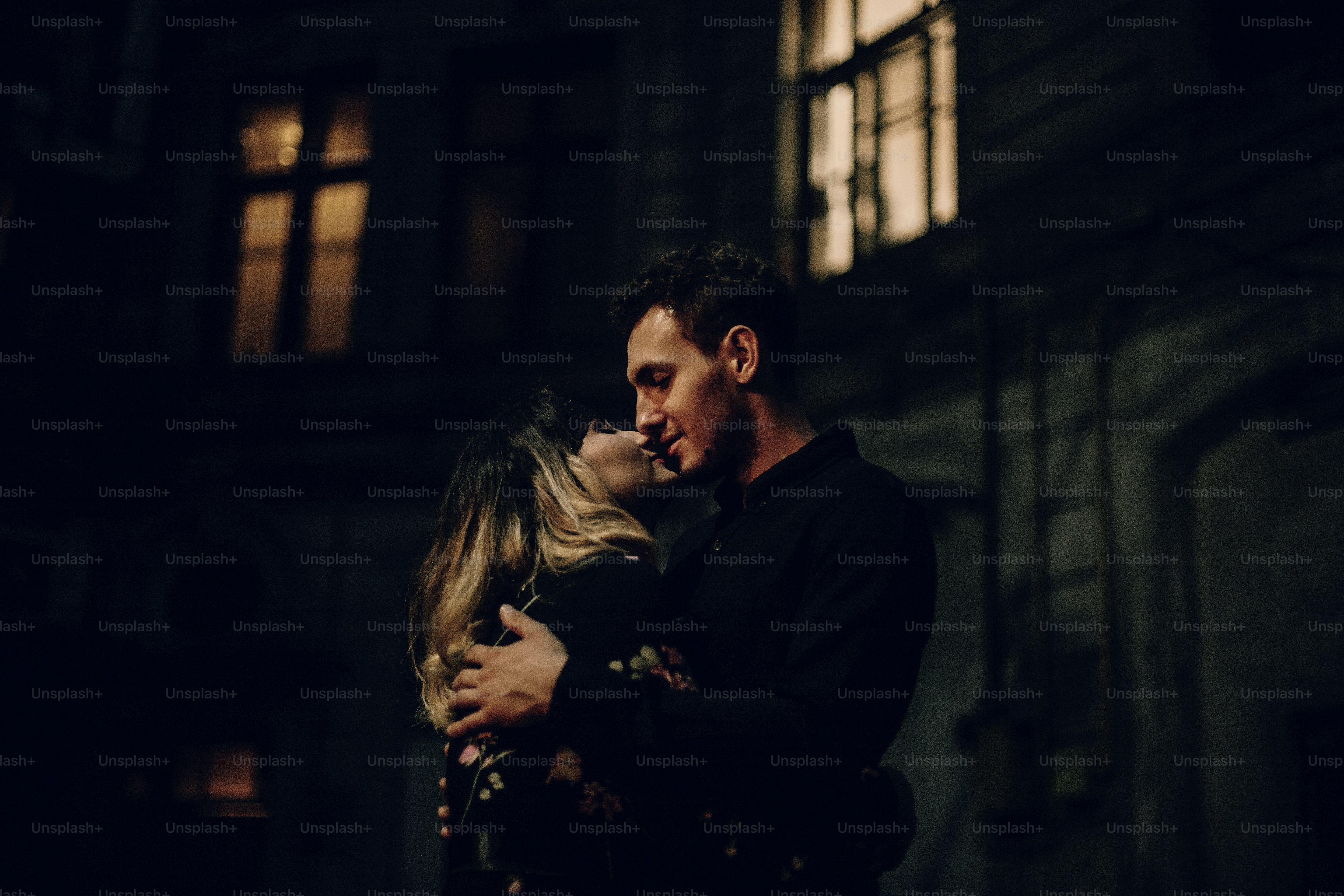 Stylish gypsy couple in love embracing in evening city street at old ...