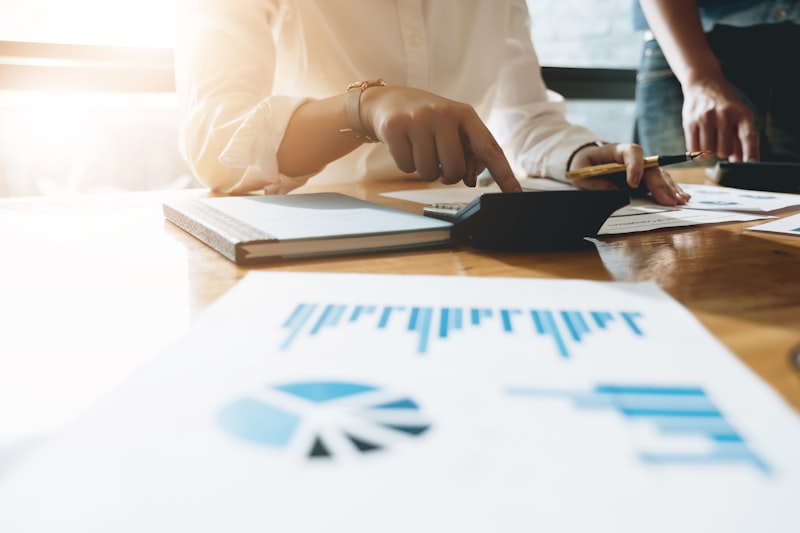 Business professionals analyzing financial documents with calculator