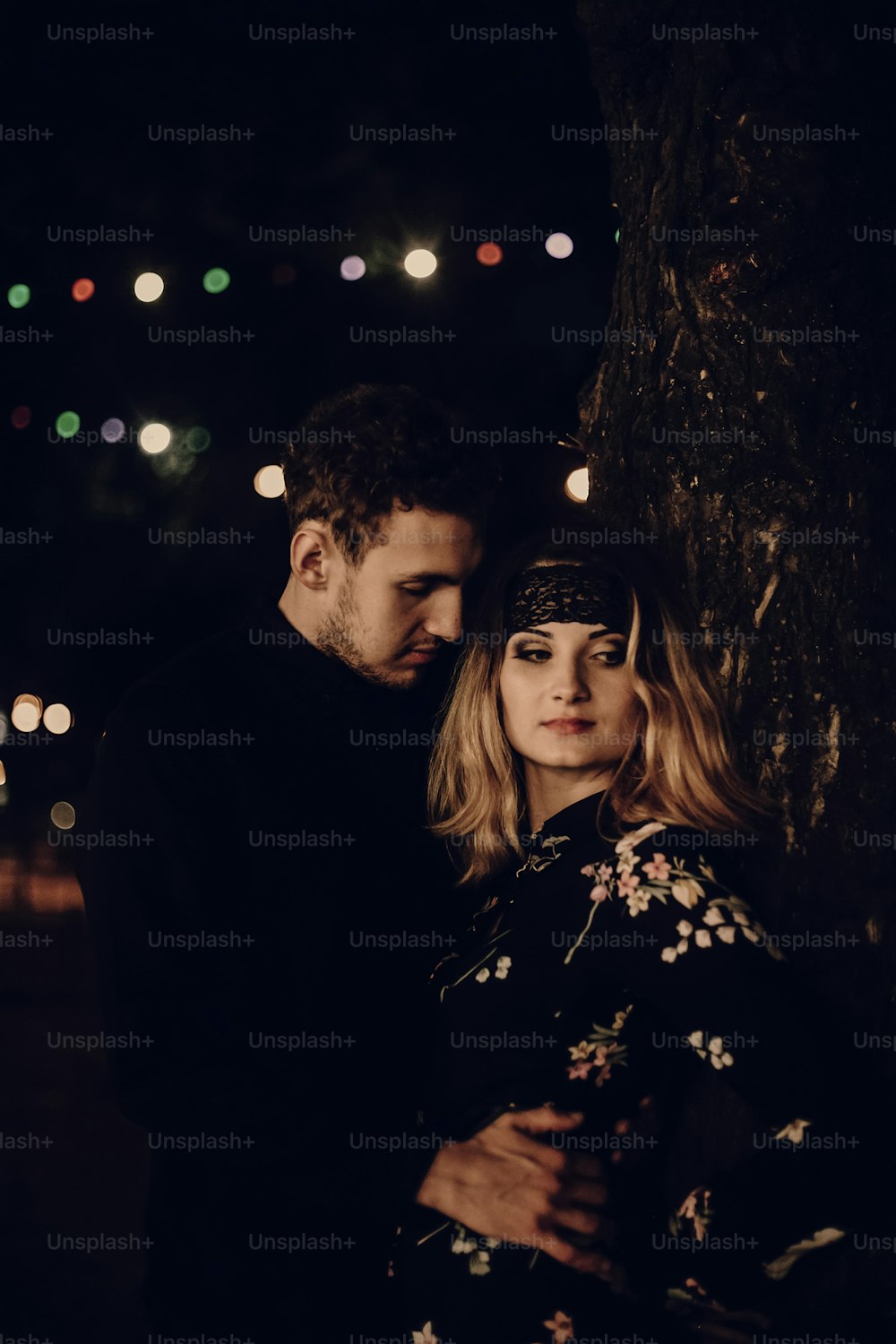 passionate gypsy bride and groom lovers embracing in evening city street. stylish couple in love gently hugging in city lights. modern woman and man romantic french atmospheric moment