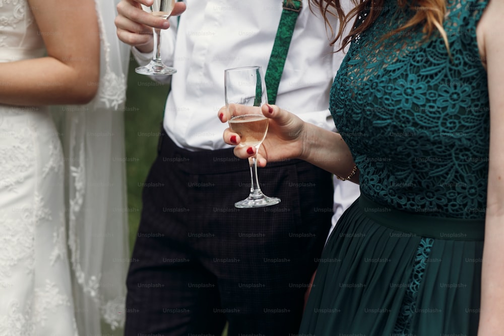 stylish wedding couple toasting with guests holding glasses of champagne. moment of wedding reception of gorgeous bride and groom