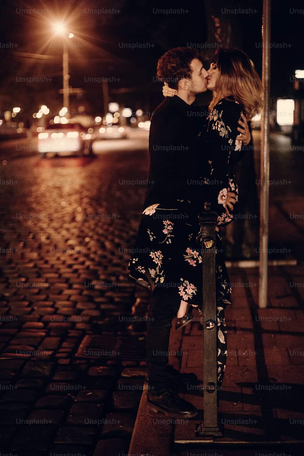Pareja besándose al aire libre en la calle, dos amantes se besan en la calle nocturna en París en su luna de miel, concepto de pasión