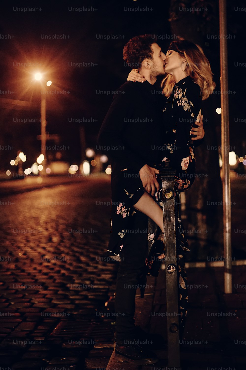 Couple kissing outdoors in the street, two lovers kiss in night street in Paris on their honeymoon, passion concept