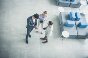 Business people standing in business building and having conversation.  Space for copy.