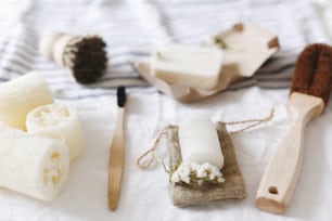 zero waste concept. natural plastic free luffa, bamboo toothbrush, brush, coconut soap and crystal deodorant, for hygiene cleaning on towel, eco bathroom essentials. sustainable lifestyle