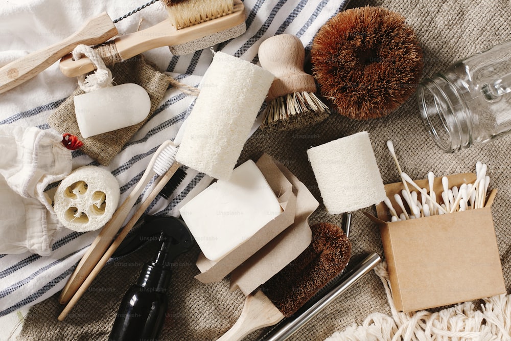 zero waste flat lay. eco natural bamboo toothbrush, brush, crystal deodorant,luffa,ear sticks, metal straws, coconut soap, cotton bags, handmade detergent. sustainable lifestyle concept