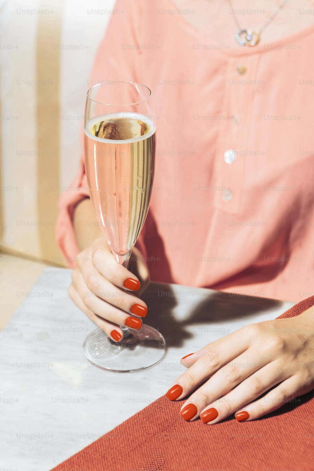 Um copo de prosecco segurado por uma jovem mulher em um bar elegante com cores pop vintage