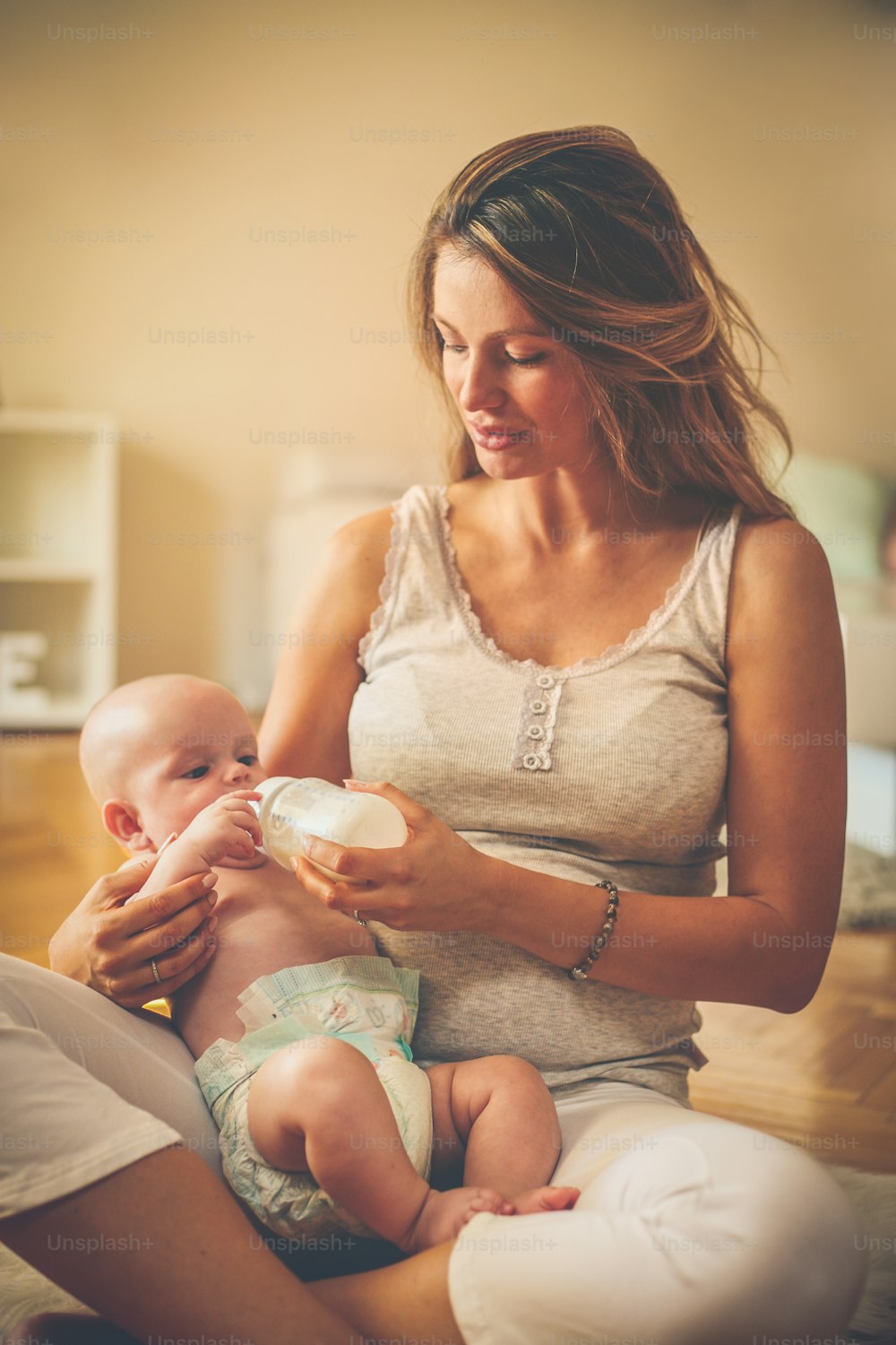 Mother with her son at home. Mother feeds her little baby.