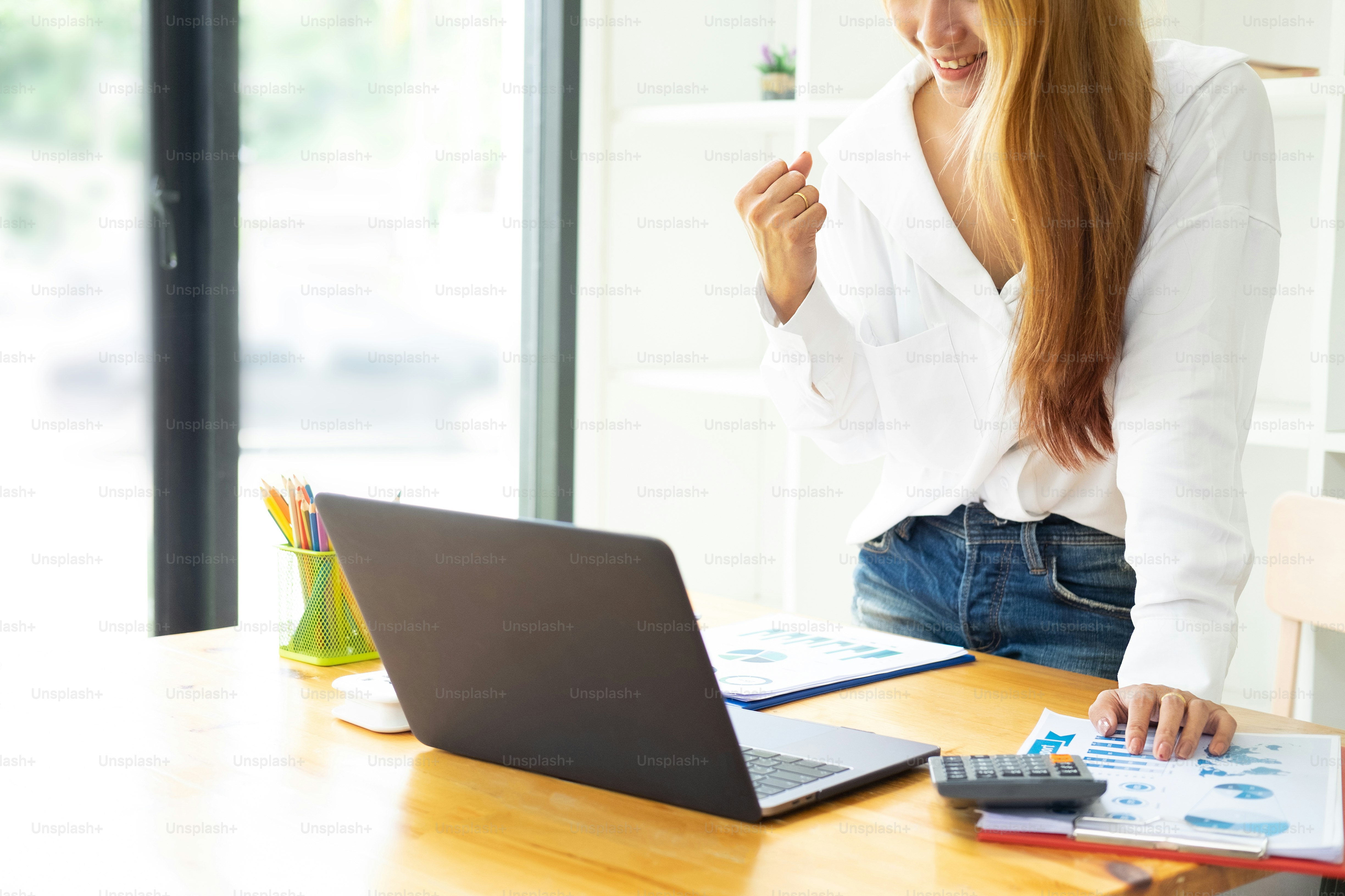 Closeup woman winner watching a laptop on a desk winning at home