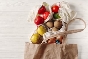 zero waste food shopping. eco natural bags with fruits and vegetables in tote, eco friendly, flat lay. sustainable lifestyle concept. plastic free items. reuse, reduce, recycle, refuse.