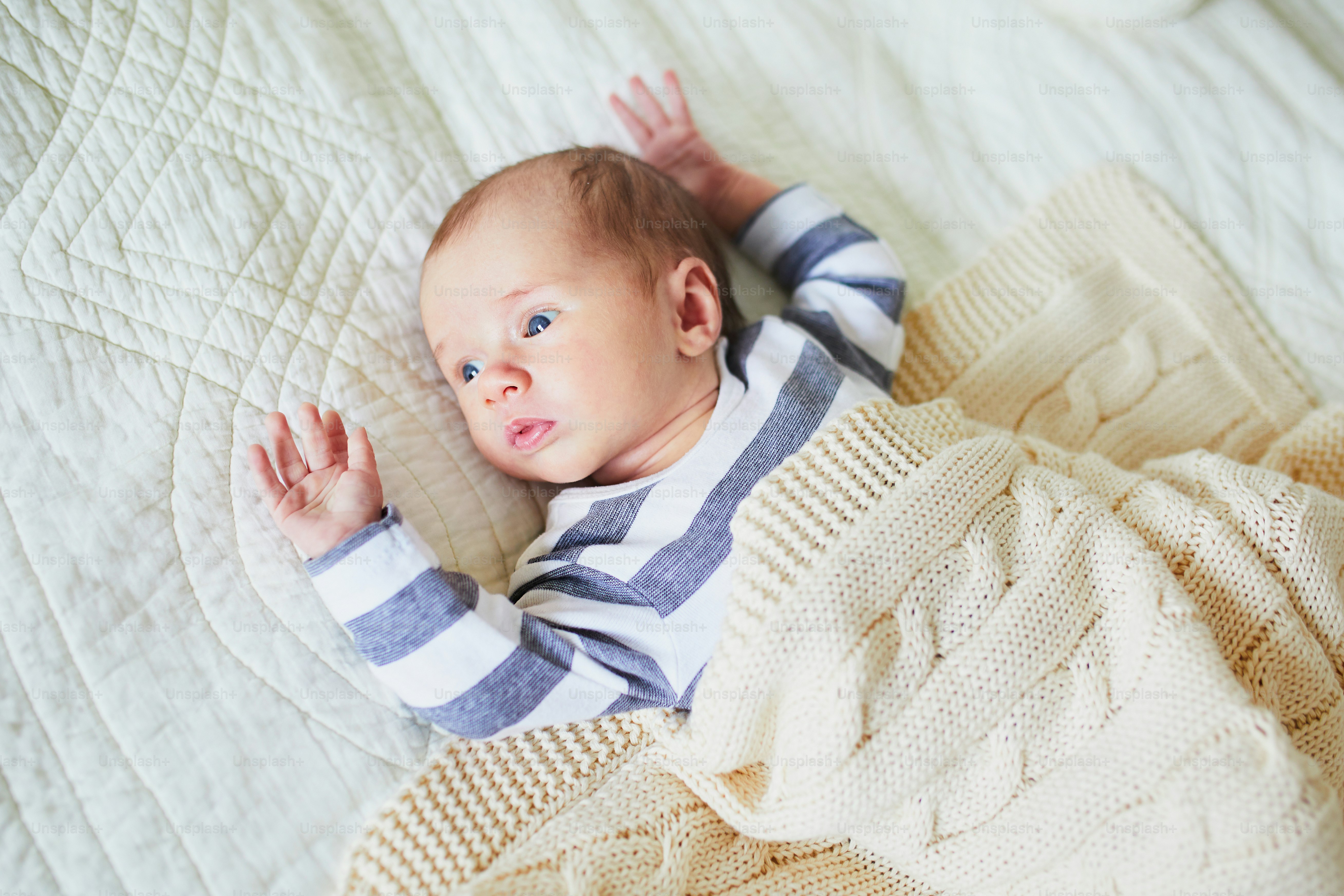 Adorable baby girl lying on bed in nursery