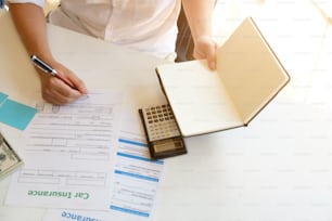 Above top view cropped shot of agent insurance working on table with finance in insurance car and health selective focus.