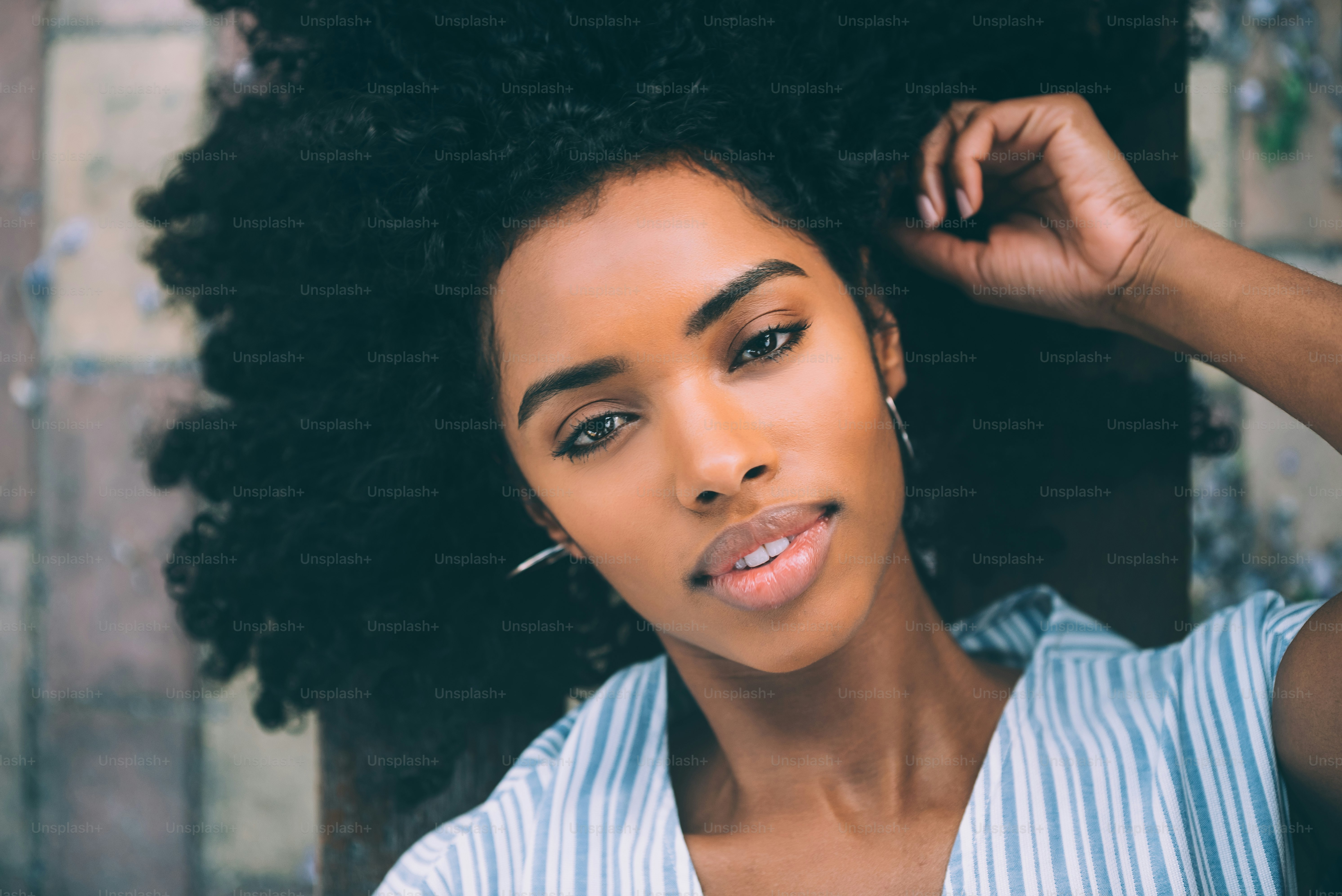 Beautiful young black woman laying down on a chair in a park