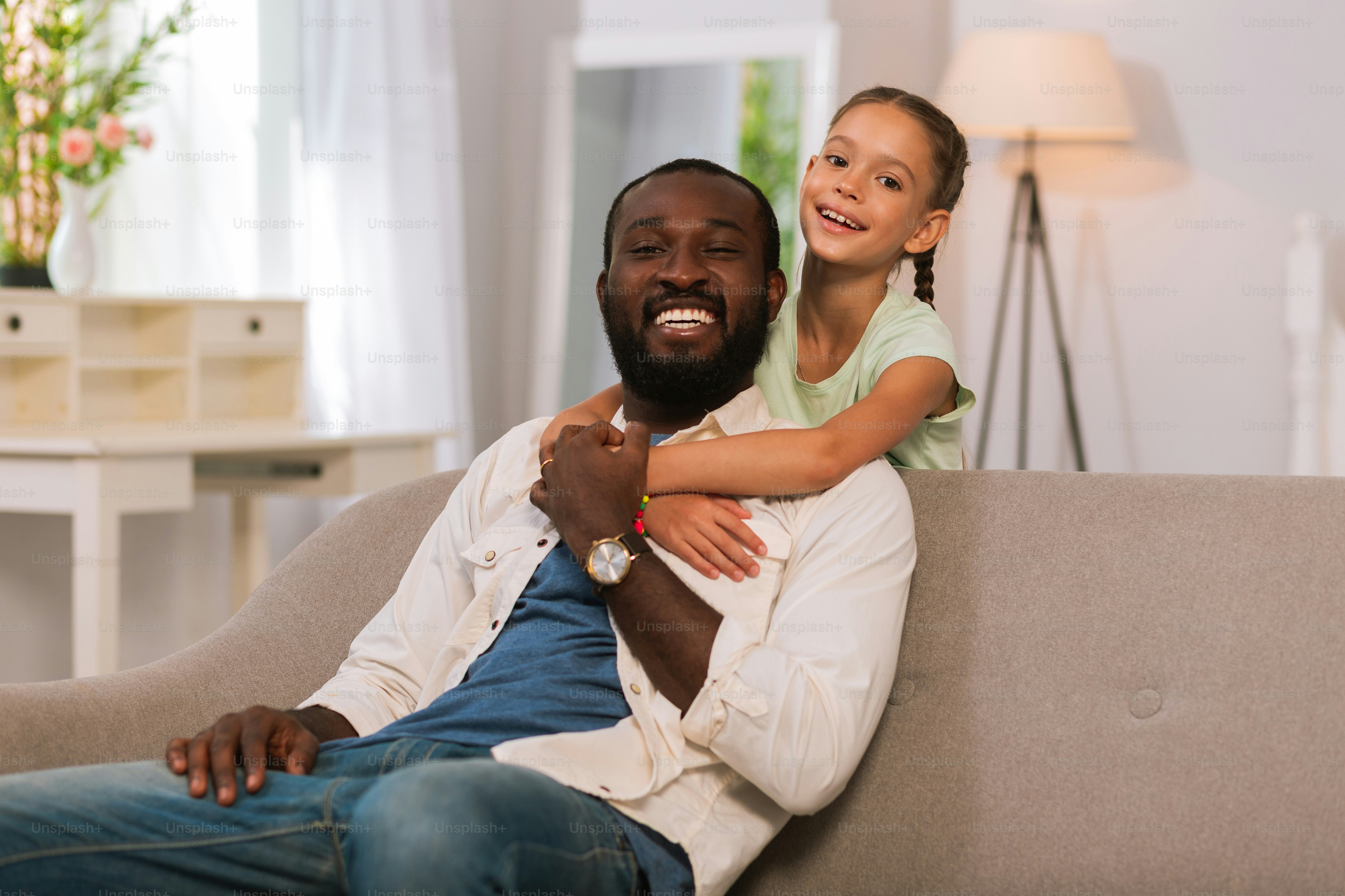 Father and daughter. Happy cute girl smiling while hugging her father